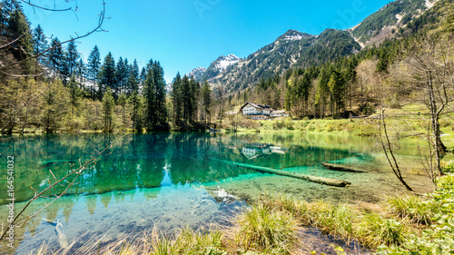Majestic mountain lake in the Alps. Traditional house at waterside.