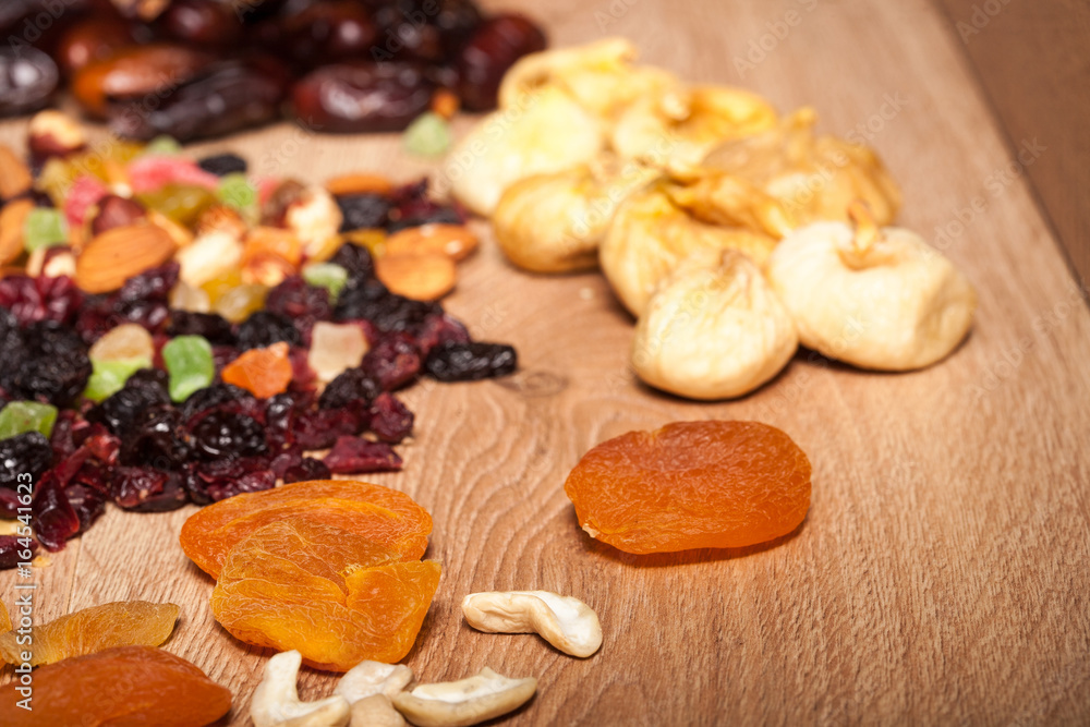 Fototapeta premium Mix of different dried fruits on wooden background. Healthy raw organic snack