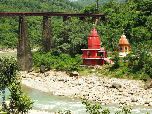 Red Hindu temple on the Kangra river near the railway bridge, Himachal Pradesh, India photo