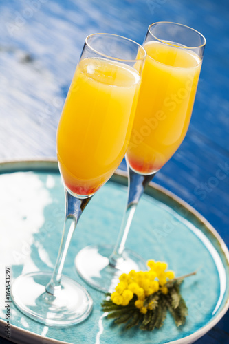 Two glasses with mimosa cocktail (sparkling wine plus orange juice)