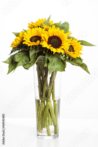 Fototapeta Naklejka Na Ścianę i Meble -  Bright sunflowers in glass vase on white background