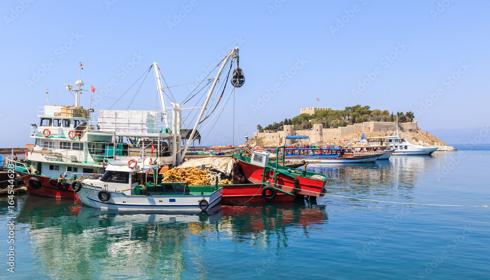 Fishing port in Kusadasi on the south coast of the Aegean Sea, Turkey. In background Guvercinada (literally: Pigeon Island) with castle and citadel