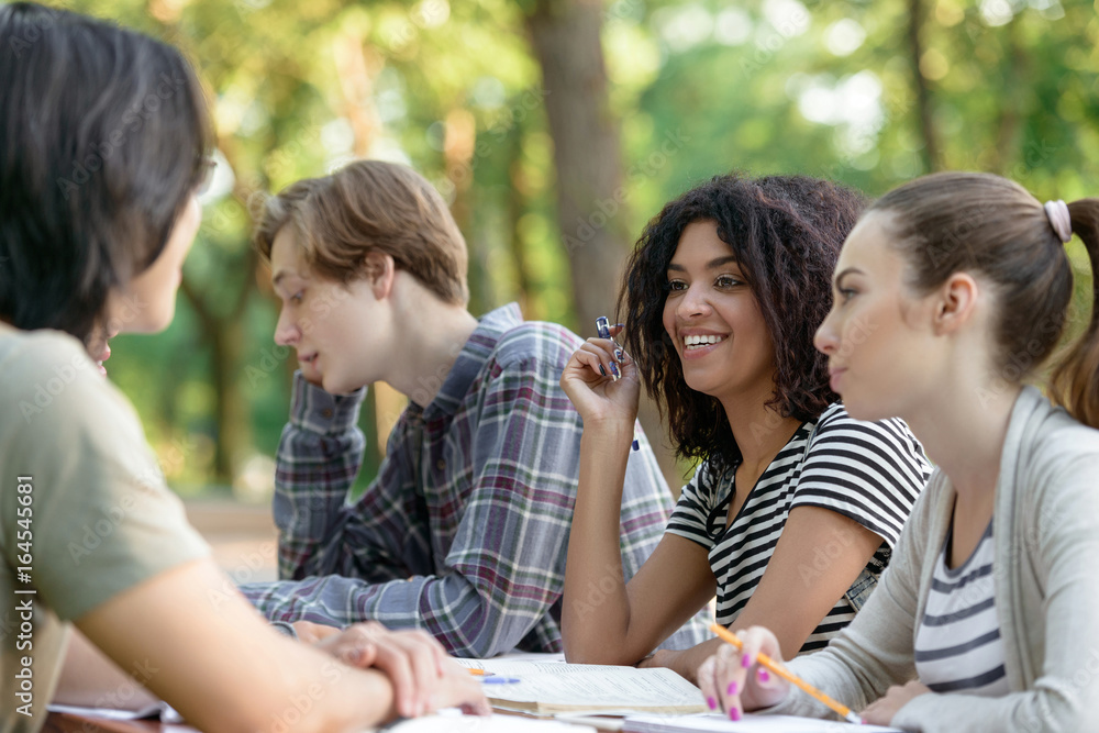Multiethnic group of smiling young students studying Multiethnic group of smiling young students studying