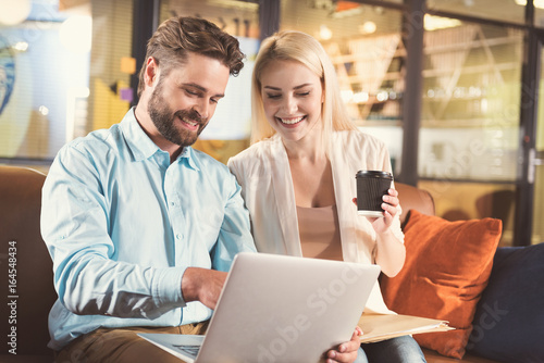 Happy youthful man and woman communicating during break at work