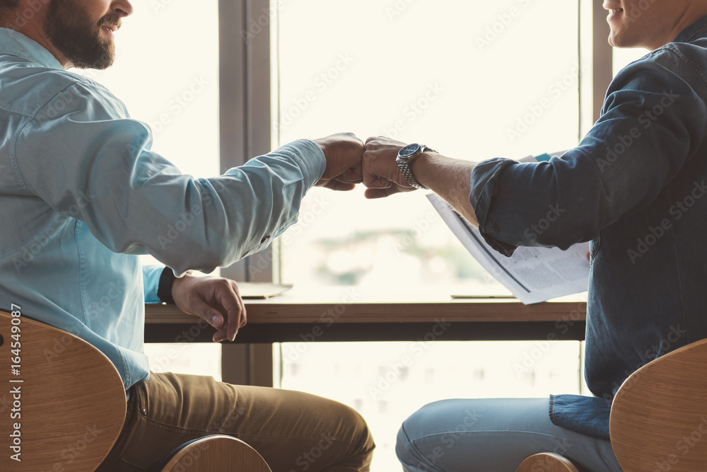 Obraz premium Youthful guys communicating together while working in office