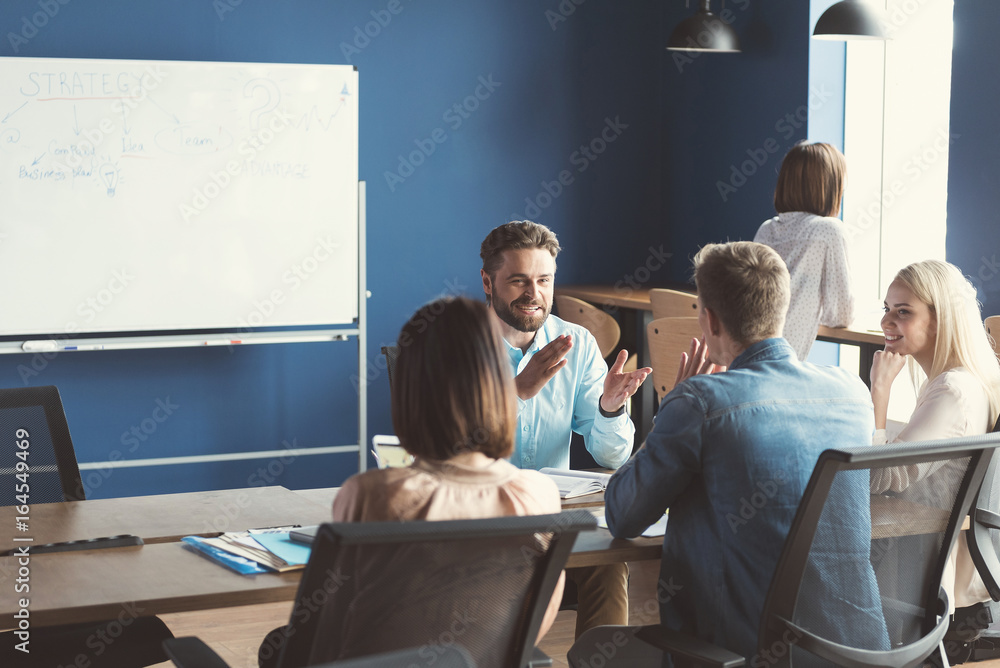 © Yakobchuk Olena - Cheerful colleagues talking together at workplace in office © Yakobchuk Olena - Cheerful colleagues talking together at workplace in office