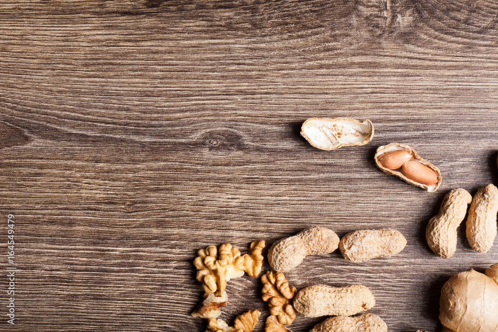 Raw organic food and nuts on wooden background. Over top view Raw organic food and nuts on wooden background. Over top view
