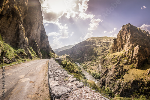 View of  sunset in the beautiful mountains and rocks on the road -  Georgia, Europe.  Road trip to Georgian War Road, Caucascus Mountaints. Golden hour and picturesque view photo