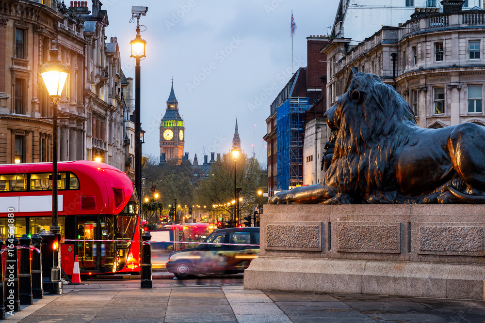 Naklejka premium Uliczny widok Trafalgar kwadrat w kierunku Big Ben przy nocą w Londyn, UK