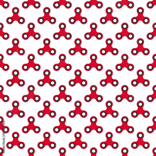 Background from red children fidget spinners on white background. Playing backdrop of hand twisting toys with bearings in a row next to each other and alternately under him