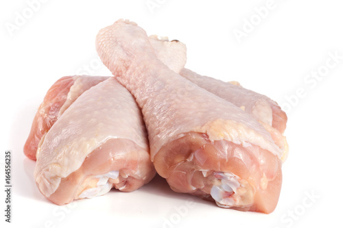 four raw chicken drumsticks isolated on white background