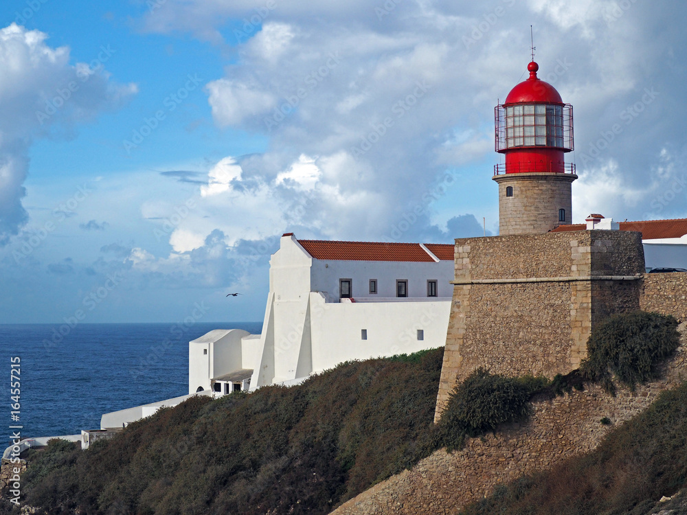 red lighthouse on Cabo de Sao Vicente with stone wall