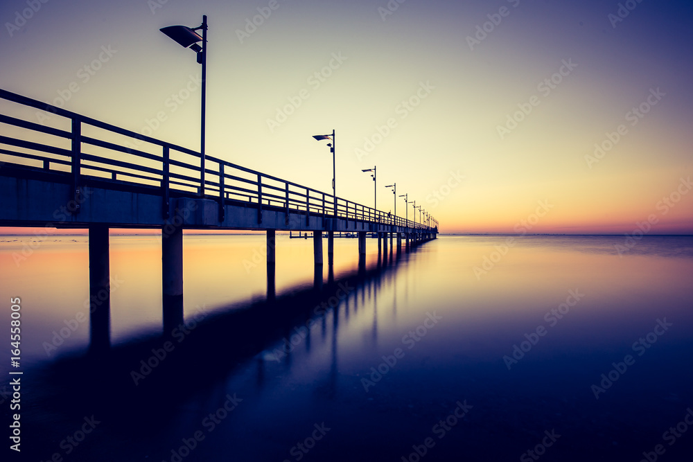 Amazing sunrise on the pier at the seaside. Gdynia Orlowo, Poland