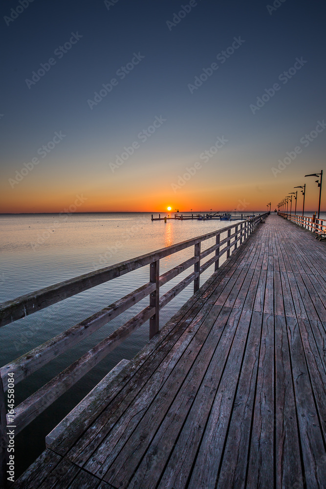 Fototapeta premium Niesamowity wschód słońca na molo nad morzem. Gdynia Orłowo, Polska