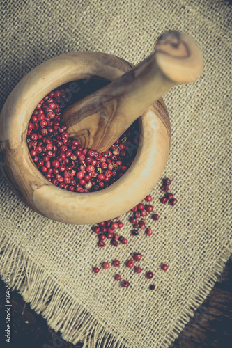 Pink pepper pile on wooden desk