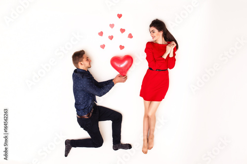 boyfriend presents his girlfriend a red balloon on a white background, a top view