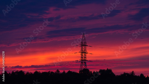 Silhouette of high voltage electrical pole structure on sunset