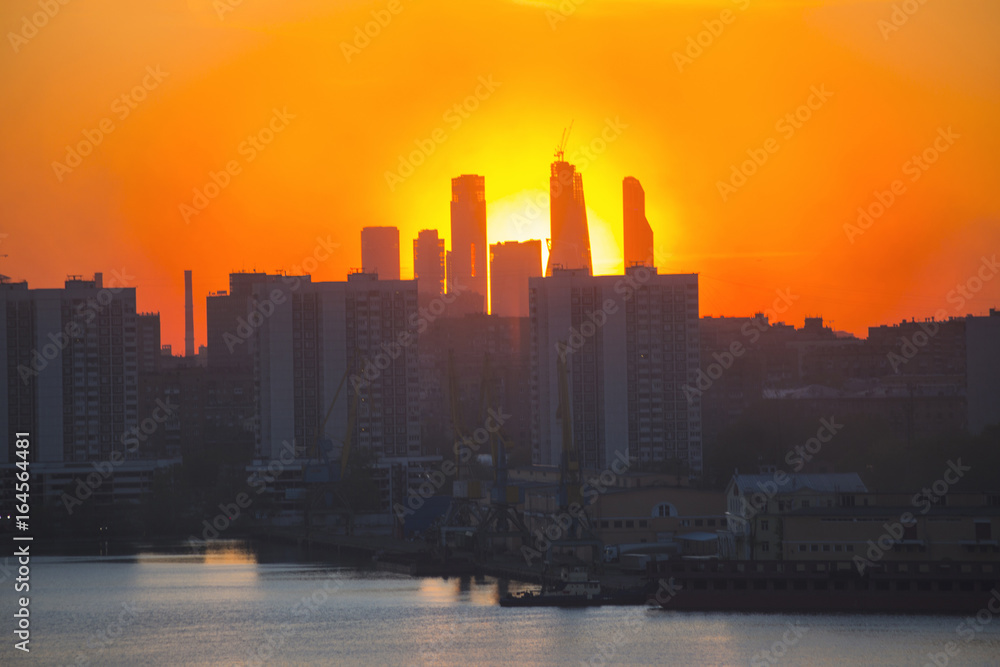 Fototapeta premium Sunrise at the city. Silhouette of buildings.