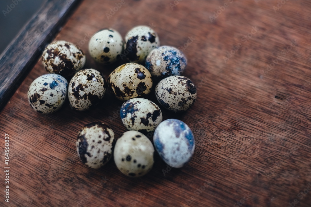 Obraz premium many quail eggs. quail eggs on the brown table. quail eggs on wooden background