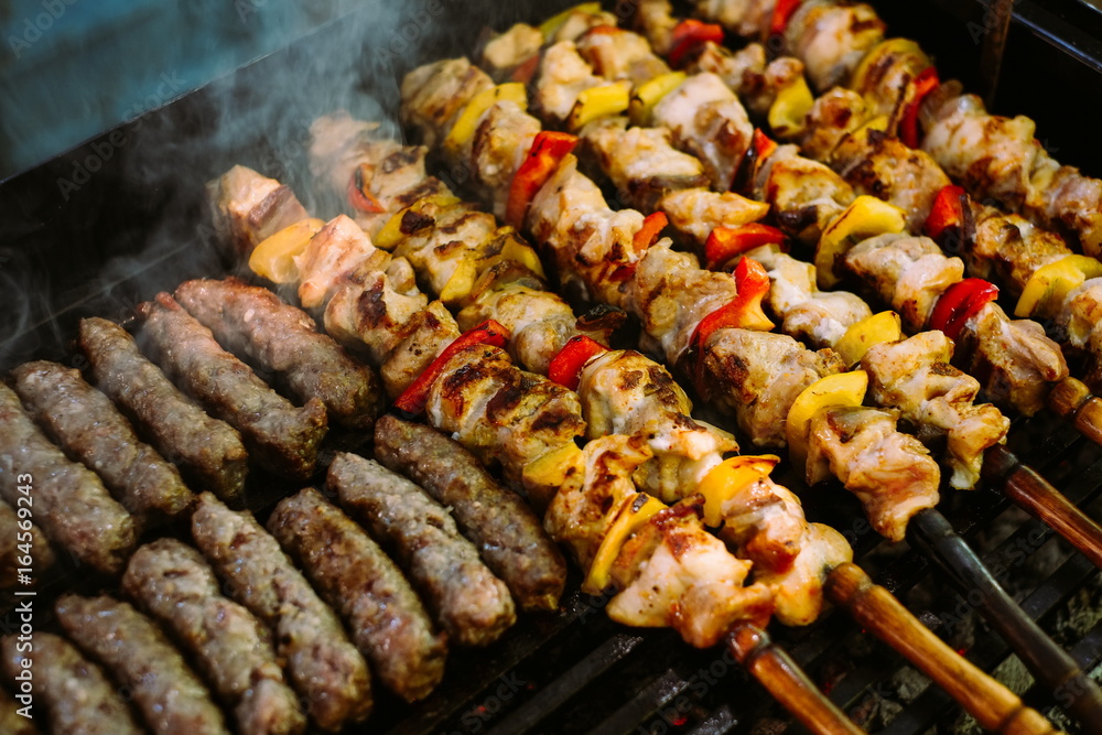 Grilling chicken meat skewers and kebab with vegetables on barbecue charcoal grill