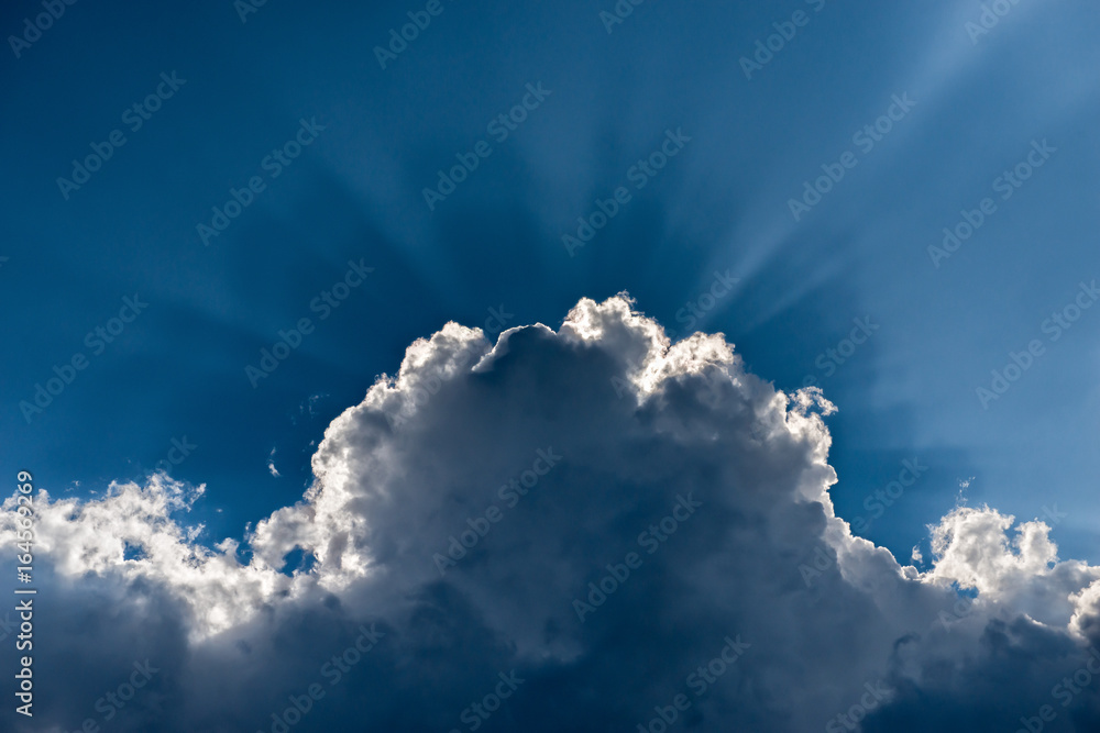 Naklejka premium Chmura burzowa Cumulonimbus na tle nieba podświetlona od tyłu światłem słonecznym