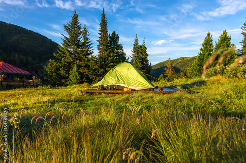 Green tent in a camping base camp in the mountains