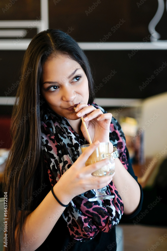 Beautiful girl drinking ice mocha shake in a cafe Beautiful girl drinking ice mocha shake in a cafe