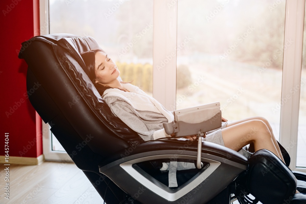 Young woman relaxing on the massaging chair