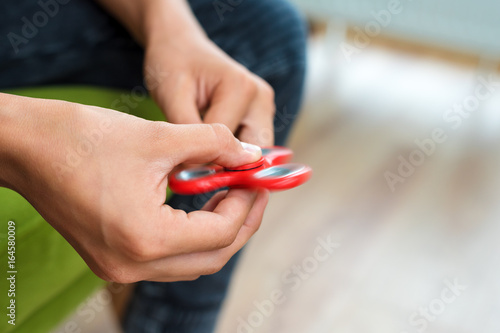Fidget spinner. Red hand spinner  fidgeting hand toy rotating on child s hand. Stress relief. Anti stress and relaxation adhd attention fad boy concept.