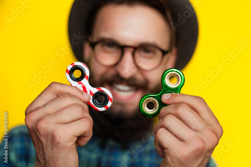 young man holding two fidget spinners photo