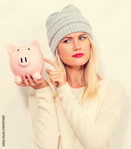 Young woman in winter clothes with a piggy bank photo