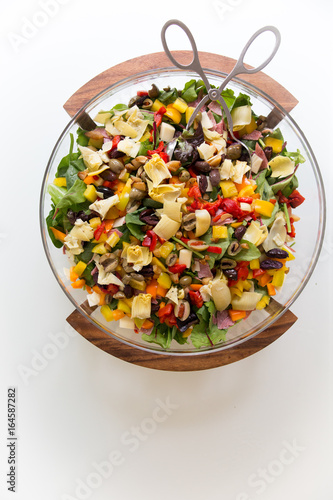 Bowl of greek salad with salami and artichokes, overhead view