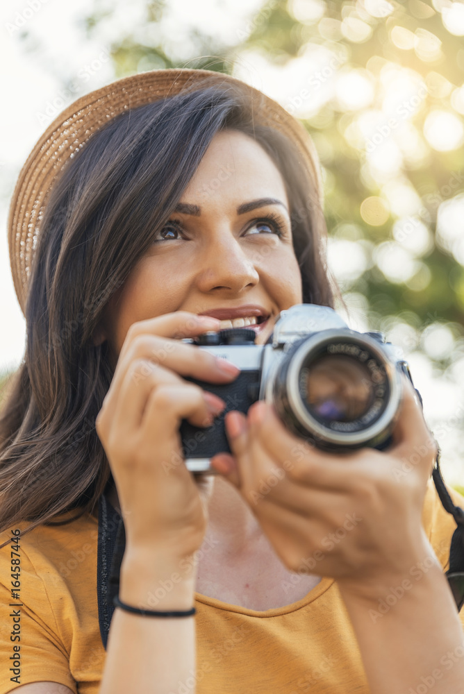 Smiling young woman using a camera to take photo. Smiling young woman using a camera to take photo.