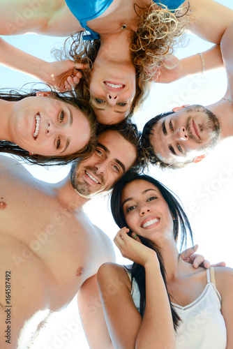 group of five friends in swimwear by the pool making funny selfie together during spring break summer holiday