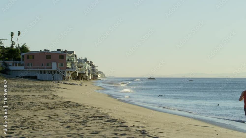 Youthful sportsman is doing his daily workout on the Pacific coast Youthful sportsman is doing his daily workout on the Pacific coast