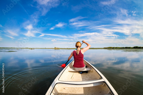 Woman sailing in Danube Delta with a boat © Calin Stan