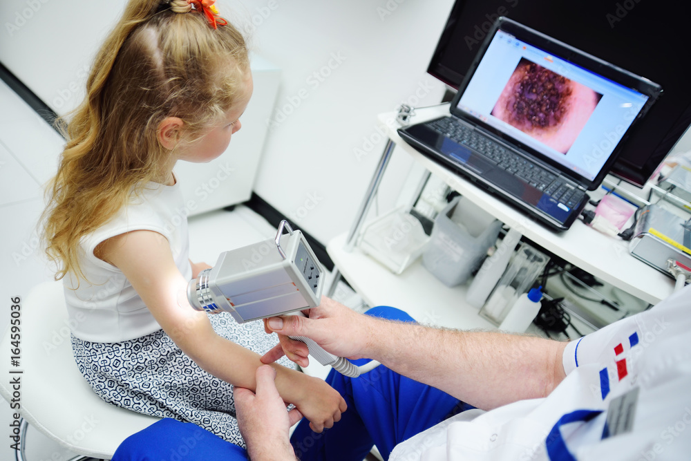 The dermatologist examines the patient's moles with the help of a special device for the dematoscopy - dermatoscope. Prevention of melanoma The dermatologist examines the patient's moles with the help of a special device for the dematoscopy - dermatoscope. Prevention of melanoma