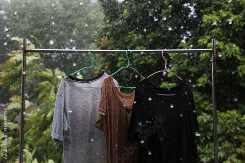 Wet clothes hang on the clothes line in the rain because can not keep up.
