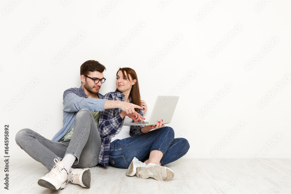 Casual couple working with laptop, studio shot Casual couple working with laptop, studio shot