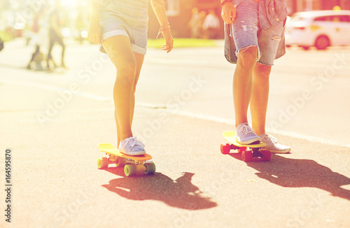 teenage couple riding skateboards on city street