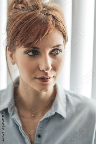 Portrait of beautiful ginger green-eyed Caucasian woman.