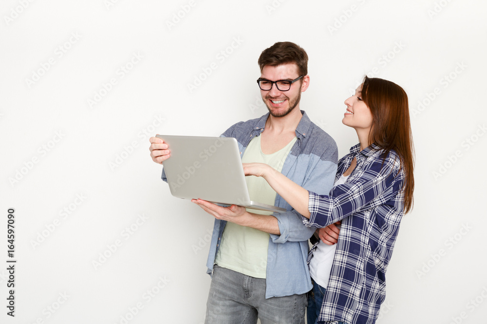Casual couple shopping online with laptop, studio shot Casual couple shopping online with laptop, studio shot