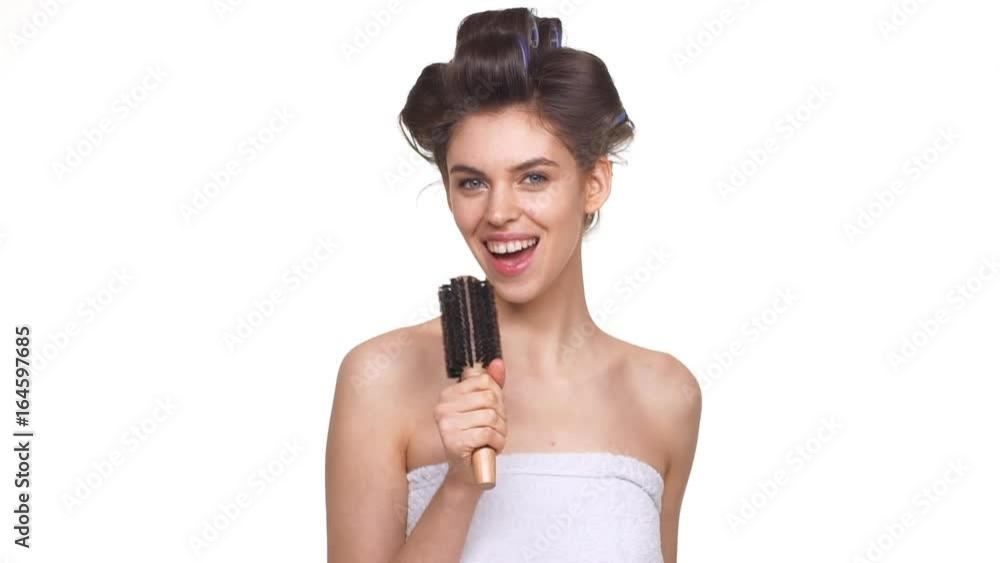 Caucasian topless lady with hair curlers having fun over white background in slowmotion. Concept of beauty and emotions Caucasian topless lady with hair curlers having fun over white background in slowmotion. Concept of beauty and emotions