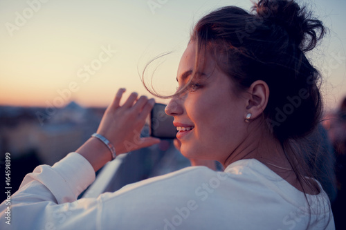 Wallpaper Mural young girl is shooting the city view by the phone and smiling Torontodigital.ca