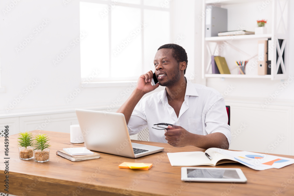 Young black businessman call mobile phone in modern white office Young black businessman call mobile phone in modern white office