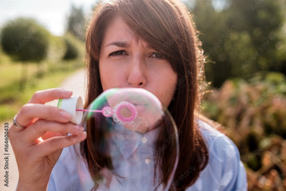 Girl blowing bubbles outdoor. Focus on lips.