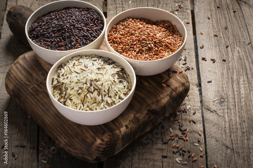 collection of different varieties of rice on wooden rustic background