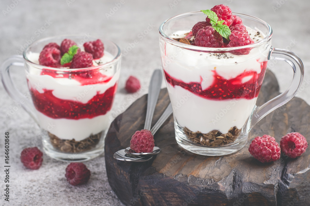 Raspberry healthy dessert or breakfast with natural yogurt in glass mugs Raspberry healthy dessert or breakfast with natural yogurt in glass mugs