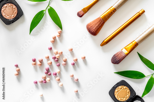 Makeup kit. Eyeshadows, brushes, blushes on white table background top view