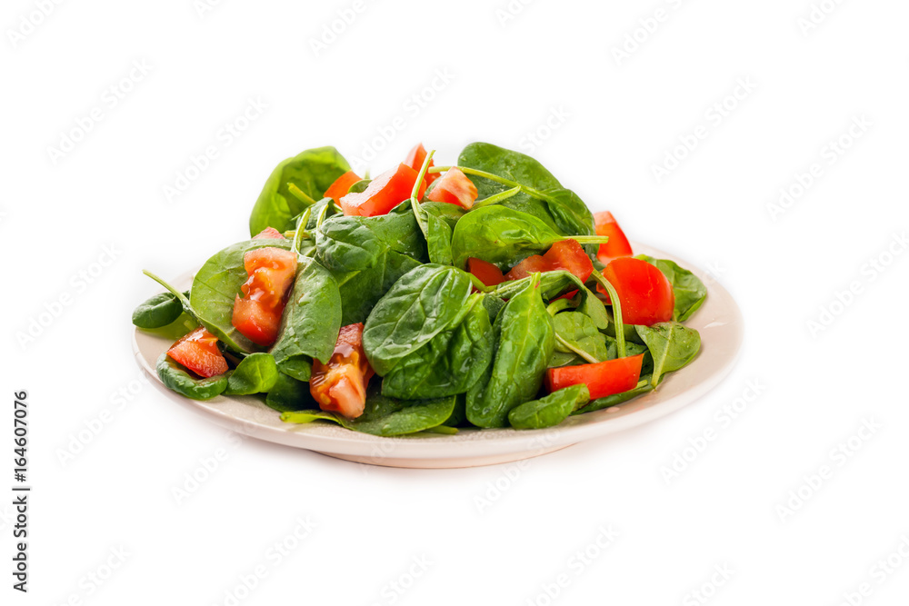 Salad with tomato, cucumber and spinach on the plate isolated on white background Salad with tomato, cucumber and spinach on the plate isolated on white background